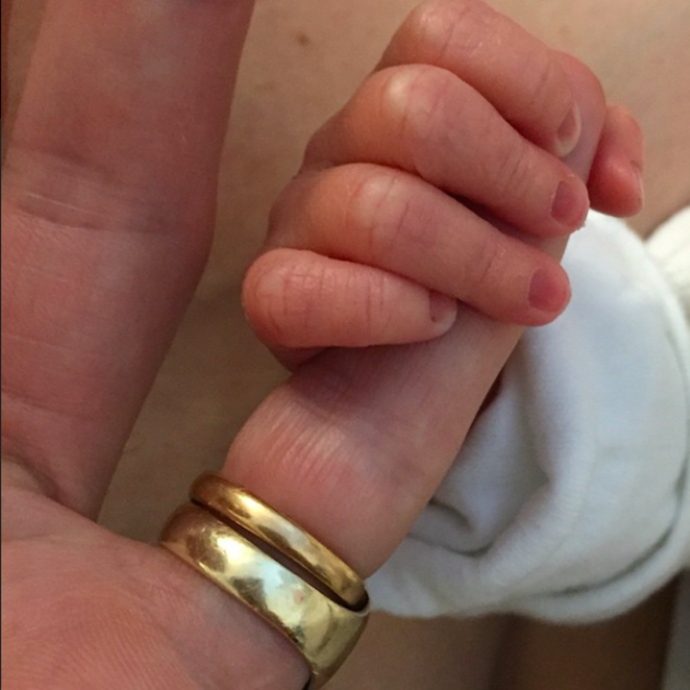 Novorozený syn drží Davida za prst.